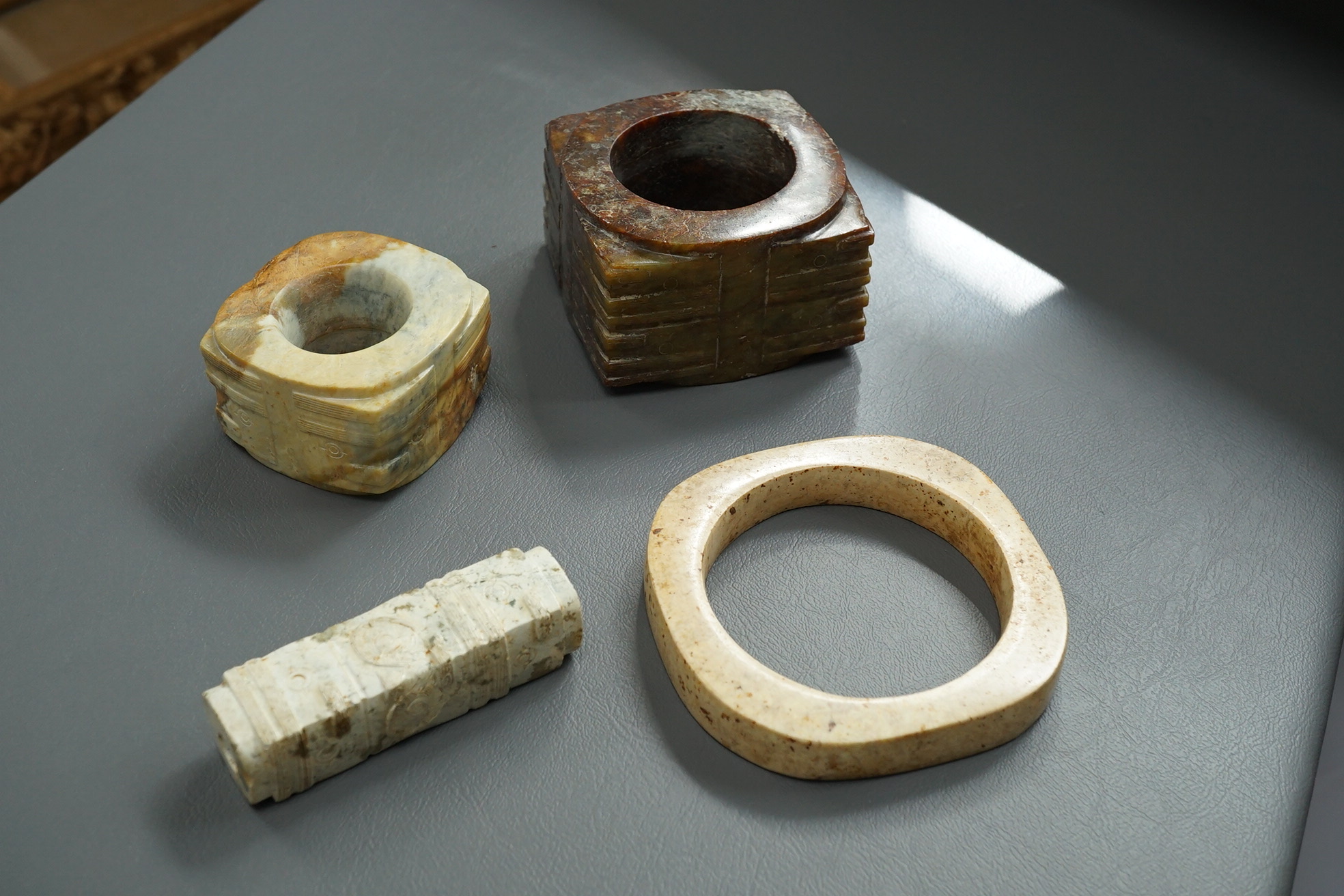 Four Chinese archaistic hardstone or burnt jade cong or cylinders